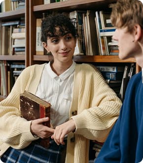 Улыбающаяся девушка с книгой что-то рассказывает интервьюеру.