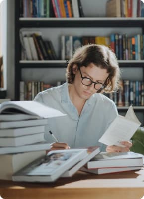 Девушка в окружении множества книг готовится к занятию.